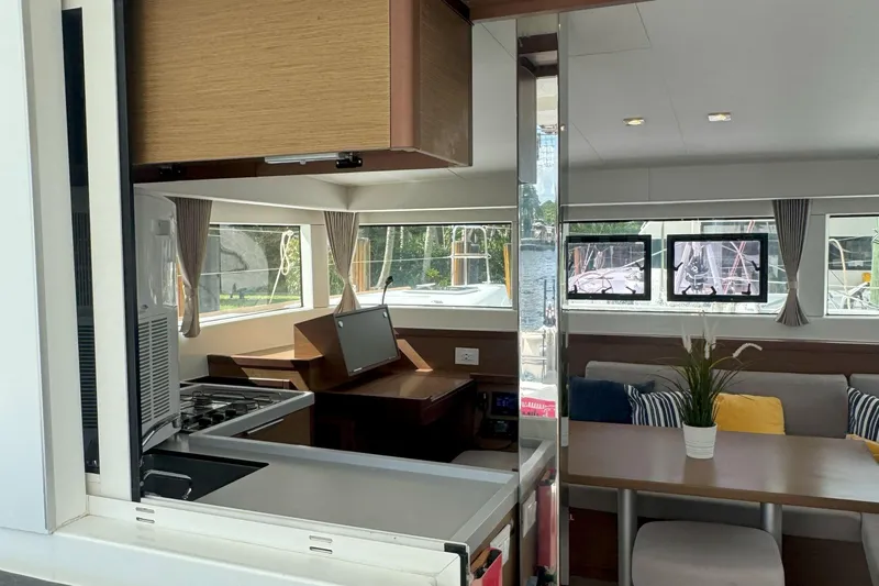 Keola Yacht Photos Pics Modern interior of 2022 Lagoon 40 catamaran with kitchen and seating area.