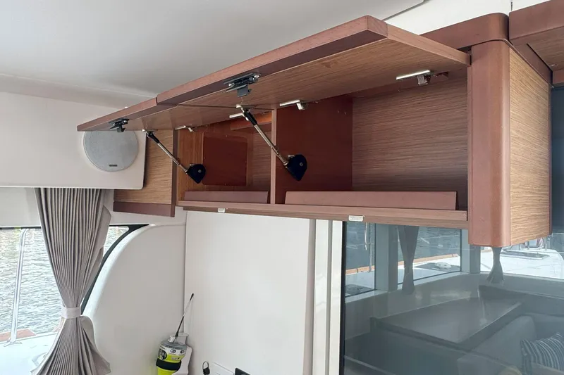 Keola Yacht Photos Pics Open wooden cabinets in a 2022 Lagoon 40 yacht interior, showcasing modern design.
