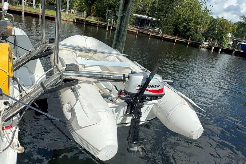 Keola Yacht Photos Pics Inflatable boat with Mariner outboard motor on Lagoon 40, 2022 model, docked by water.