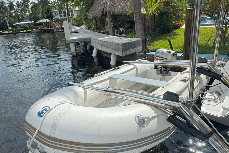 Keola Yacht Photos Pics Inflatable boat docked by a wooden pier, featuring a Mariner outboard motor.