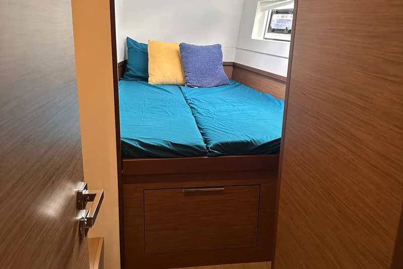 Keola Yacht Photos Pics Cozy cabin interior of 2022 Lagoon 40 catamaran with teal bedding and pillows.