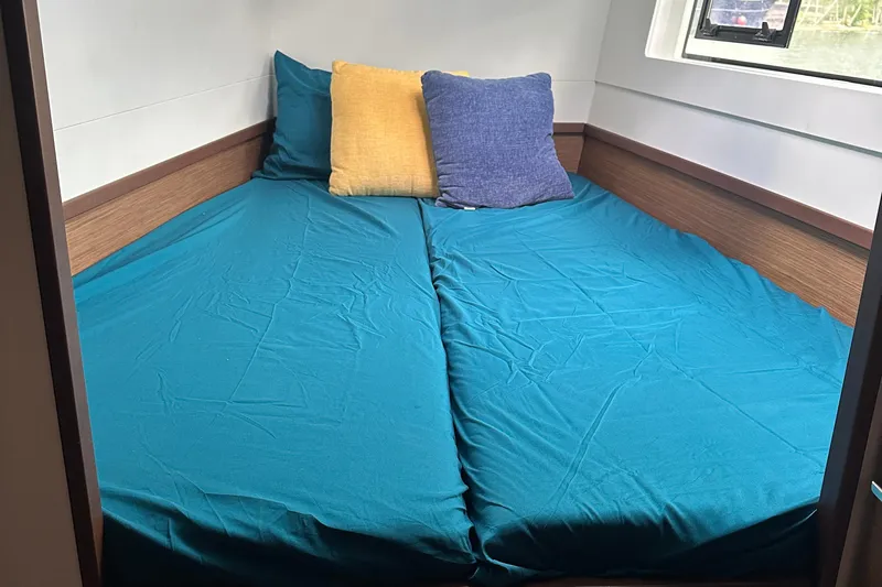 Keola Yacht Photos Pics Interior cabin of 2022 Lagoon 40 catamaran with teal bedding and colorful pillows.