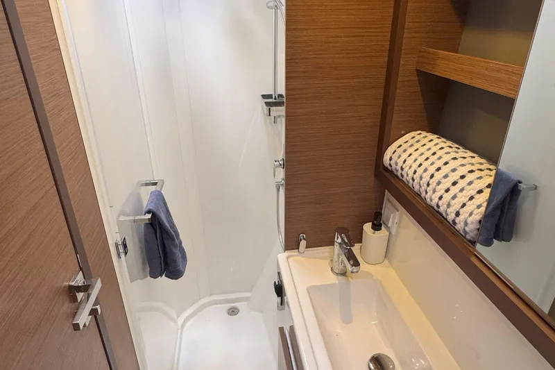 Keola Yacht Photos Pics Modern bathroom in 2022 Lagoon 40 yacht with shower, sink, and wooden accents.