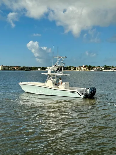 Cheers Yacht Photos Pics 2020 Invincible 33 Open Fisherman boat on calm waters under a blue sky.