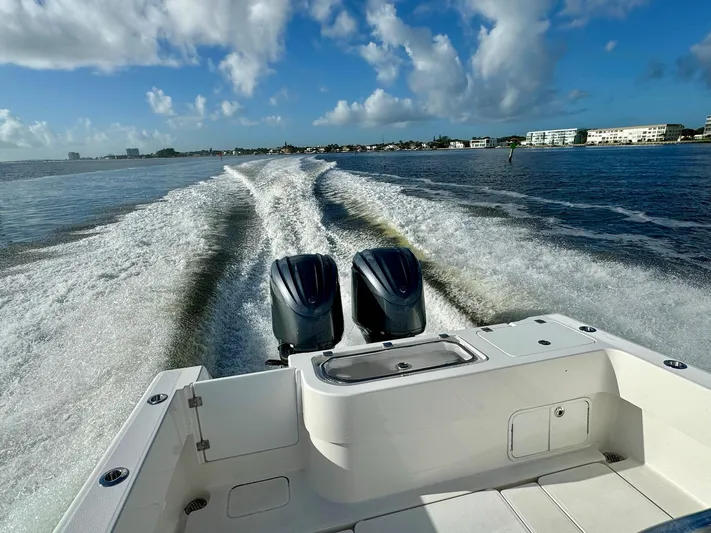 Cheers Yacht Photos Pics 2020 Invincible 33 Open Fisherman boat cruising on open water, twin engines visible.