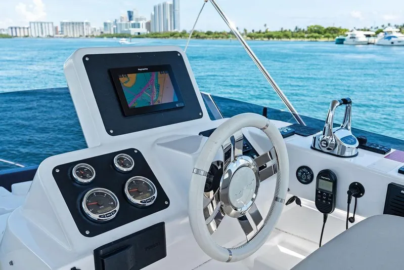  Yacht Photos Pics Cockpit of 2021 Azimut Magellano 43 yacht with navigation controls and city skyline view.