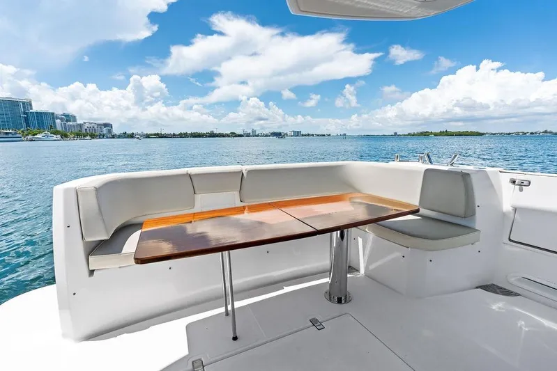  Yacht Photos Pics 2021 Azimut Magellano 43 yacht deck with seating and table, overlooking scenic waterfront.