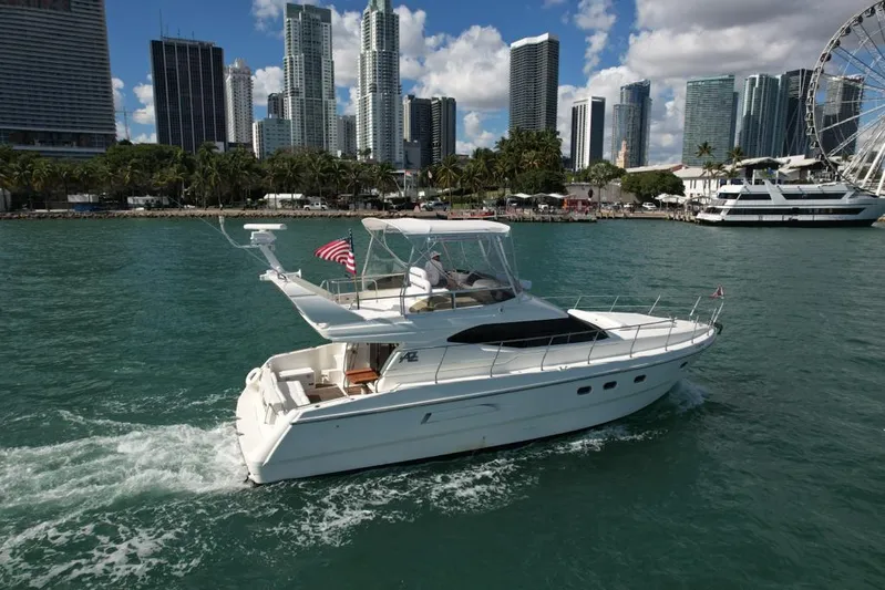  Yacht Photos Pics Azimut 43 yacht cruising near city skyline, 1997 model, with American flag.