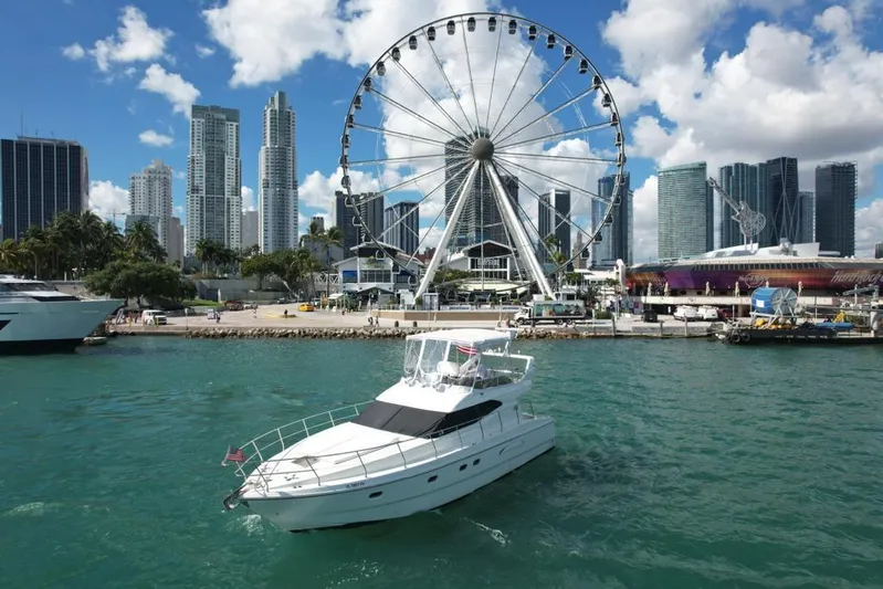  Yacht Photos Pics Azimut 43 yacht cruising near a Ferris wheel and city skyline, 1997 model.