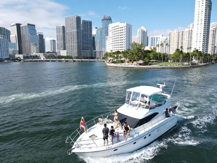  Yacht Photos Pics Azimut 43 yacht cruising near city skyline, 1997 model, with people enjoying the ride.