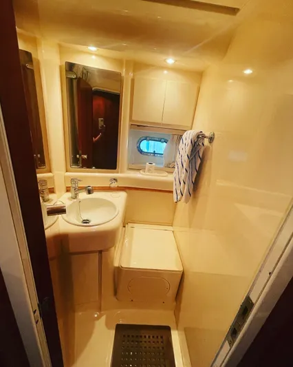  Yacht Photos Pics Bathroom interior of 1997 Azimut 43 yacht with sink, mirror, and porthole window.