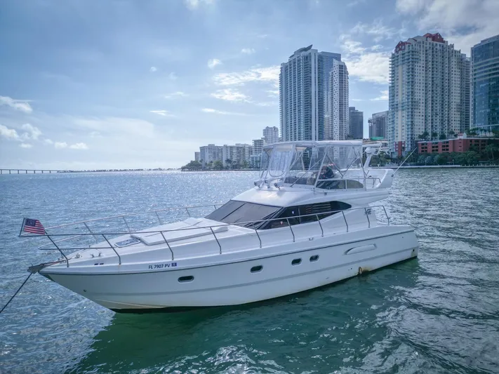  Yacht Photos Pics Azimut 43 yacht from 1997 on water, city skyline in background.