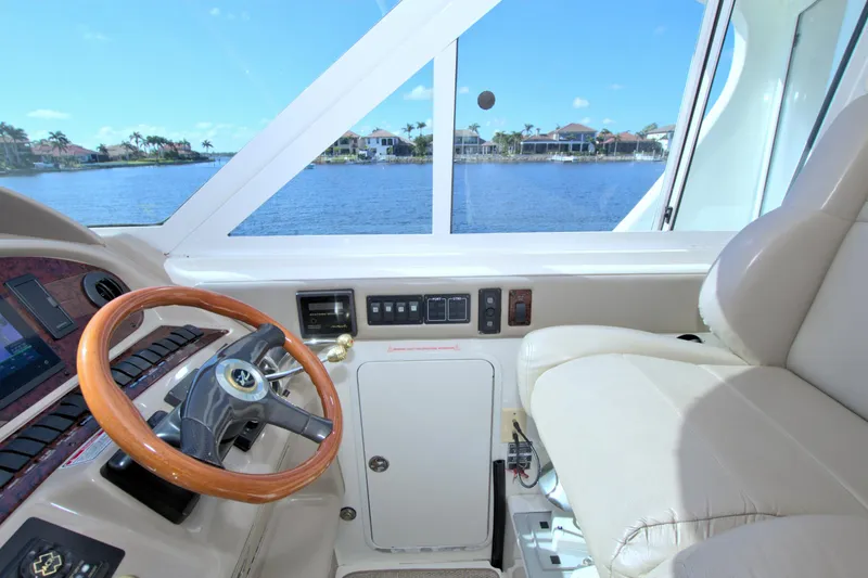 You, Me And The Sea Yacht Photos Pics 2003 Sea Ray 480 Motor Yacht helm with wooden steering wheel and waterfront view.