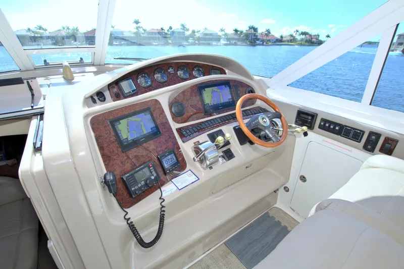 You, Me And The Sea Yacht Photos Pics 2003 Sea Ray 480 Motor Yacht helm with navigation screens and wooden steering wheel.