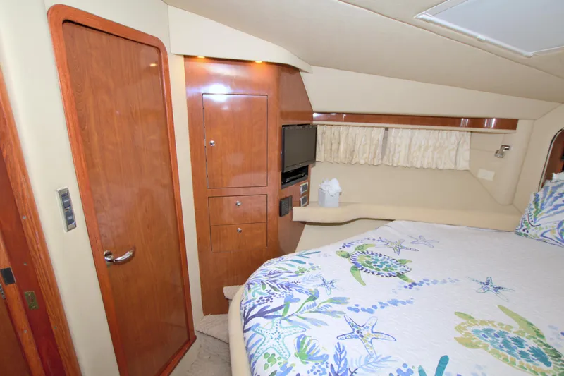 You, Me And The Sea Yacht Photos Pics Luxurious 2003 Sea Ray 480 Motor Yacht bedroom with wooden cabinetry and nautical-themed bedding.