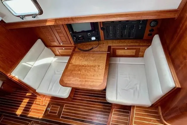 Blue Moon Yacht Photos Pics 2016 Gozzard 41 RC yacht interior with wooden table and cushioned seating.