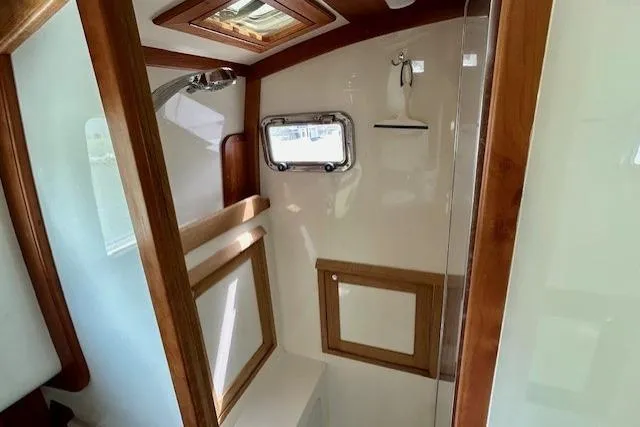 Blue Moon Yacht Photos Pics Interior of 2016 Gozzard 41 RC yacht bathroom with wooden accents and porthole window.