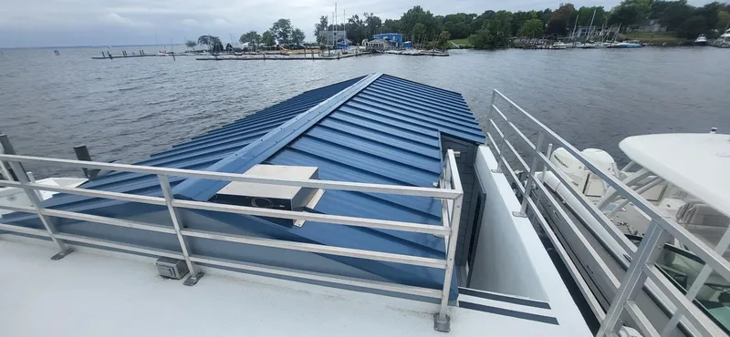  Yacht Photos Pics 2020 Destination Yachts 16x45 Condo Series houseboat with blue roof on a lake.