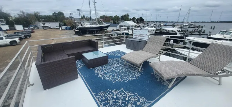  Yacht Photos Pics 2020 Destination Yachts 16x45 Condo Series rooftop with lounge chairs and sofa on a marina.