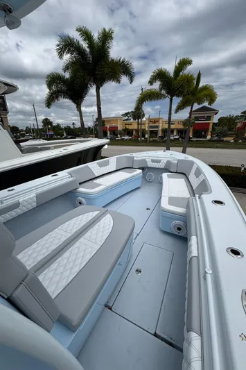 35-261 Yacht Photos Pics 2025 Contender 35 ST boat interior with cushioned seating, set against a tropical backdrop.