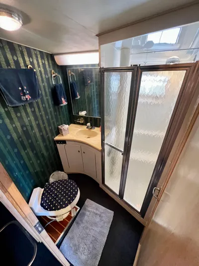 White Shark Yacht Photos Pics Bathroom interior of 1988 Hatteras 48 Convertible yacht with shower, sink, and toilet.
