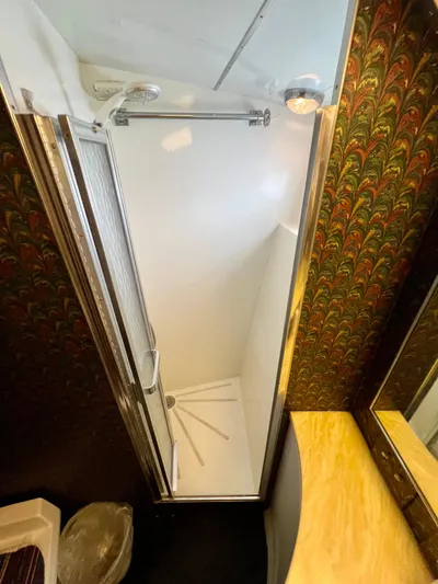 White Shark Yacht Photos Pics Shower area in 1988 Hatteras 48 Convertible yacht with patterned wallpaper and wooden countertop.