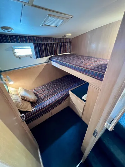 White Shark Yacht Photos Pics 1988 Hatteras 48 Convertible cabin with bunk beds and striped bedding.