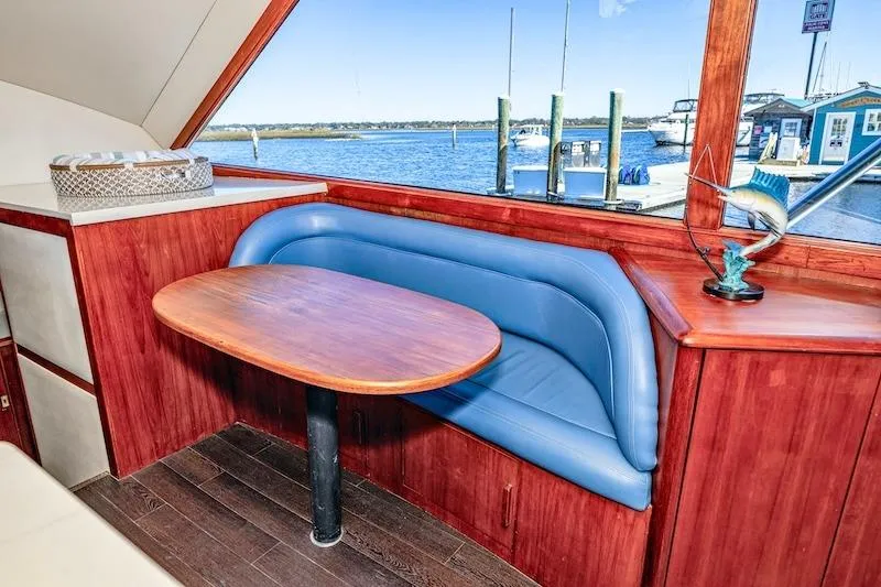 Obsidian Yacht Photos Pics Interior of 1991 Ocean Yachts 53 Super Sport with blue seating and wooden table.
