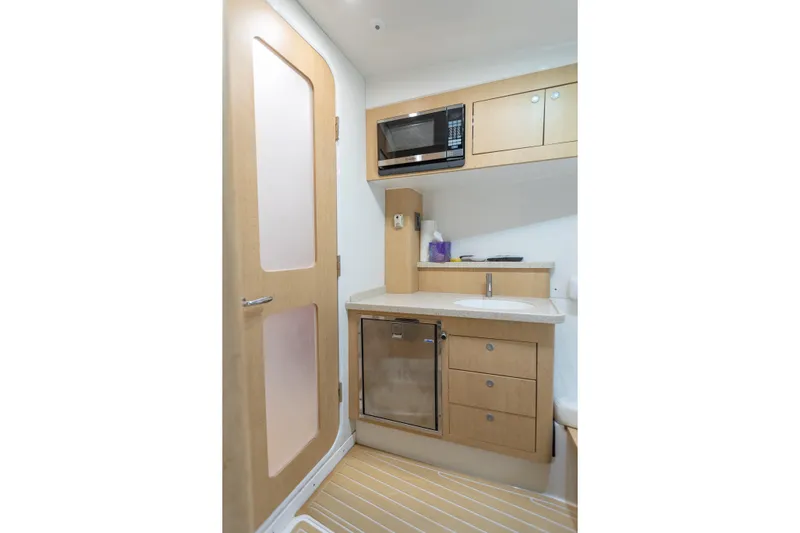 Liberado Yacht Photos Pics Compact kitchenette in 2018 HCB 53 Suenos RXV with microwave, sink, and storage cabinets.