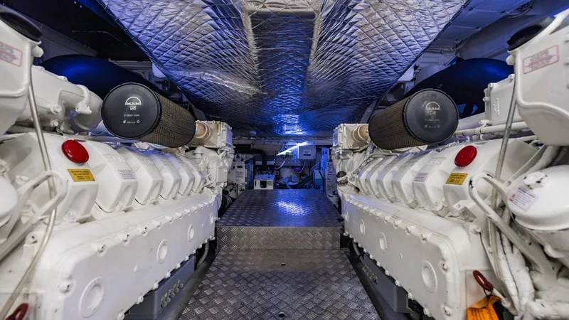 Unreel Yacht Photos Pics Engine room of 2023 Pershing 7X yacht, featuring dual powerful engines and metallic flooring.