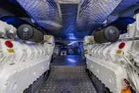 Engine room of 2023 Pershing 7X yacht, featuring dual powerful engines and metallic flooring.