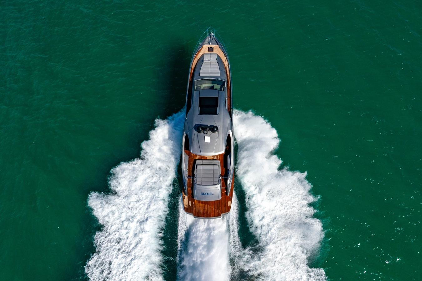 2023 Pershing 7X yacht cruising on turquoise water, aerial view.