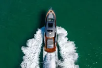 2023 Pershing 7X yacht cruising on turquoise water, aerial view.