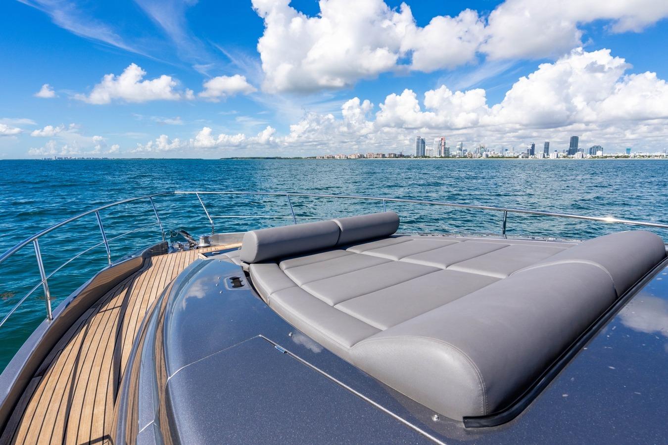 2023 Pershing 7X yacht deck with city skyline and ocean view.