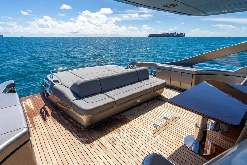Unreel Yacht Photos Pics Luxurious 2023 Pershing 7X yacht deck with seating, overlooking the ocean.