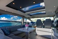 Luxurious interior of 2023 Pershing 7X yacht with panoramic ocean views and modern seating.