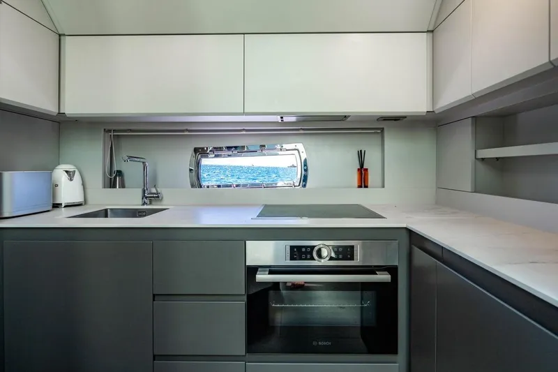 Unreel Yacht Photos Pics Modern kitchen interior on 2023 Pershing 7X yacht with sleek appliances and ocean view.