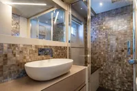 Luxurious bathroom in 2023 Pershing 7X yacht with modern sink and mosaic tiles.