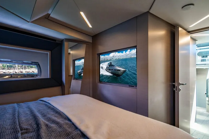 Unreel Yacht Photos Pics Luxurious interior of 2023 Pershing 7X yacht with modern bedroom and scenic window view.