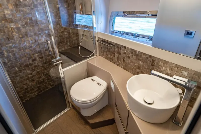 Unreel Yacht Photos Pics Luxurious bathroom in 2023 Pershing 7X yacht with modern fixtures and ocean view.