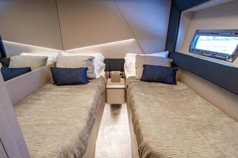 Unreel Yacht Photos Pics Luxurious twin cabin interior of 2023 Pershing 7X yacht with modern design and window view.