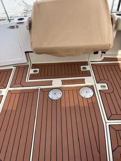 Marcia Jean Yacht Photos Pics 2023 Ranger Tugs R-29 S boat deck with teak-style flooring and covered seating.