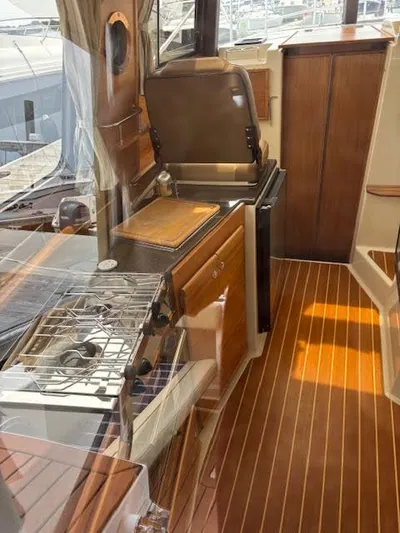 Marcia Jean Yacht Photos Pics 2023 Ranger Tugs R-29 S interior with wooden flooring and compact kitchen area.