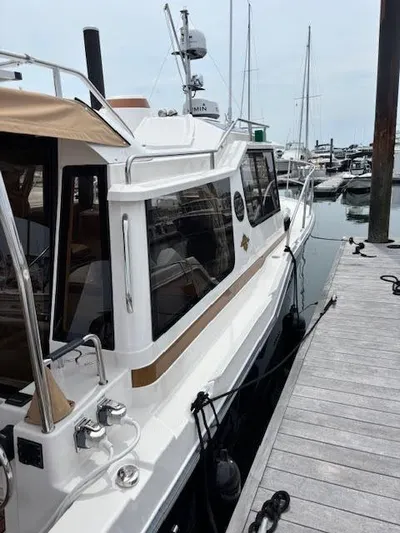 Marcia Jean Yacht Photos Pics 2023 Ranger Tugs R-29 S docked at a marina, showcasing sleek design and modern features.