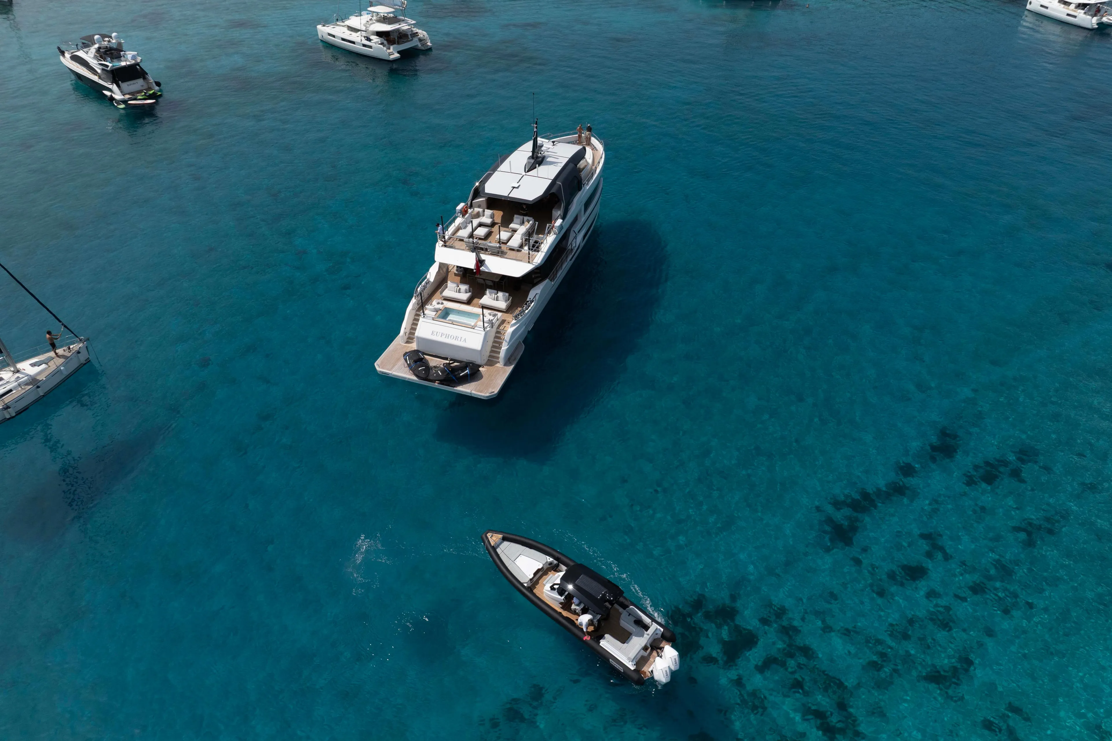 Aerial view of luxury yachts, featuring 2025 Alpha 100 Squalo Co Ownership, in clear blue waters.