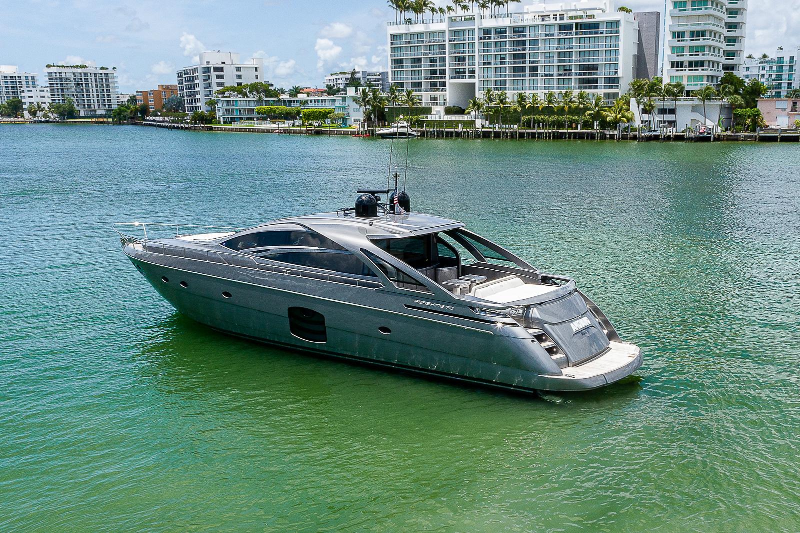 2015 Pershing 70 yacht on calm water with modern buildings in the background.