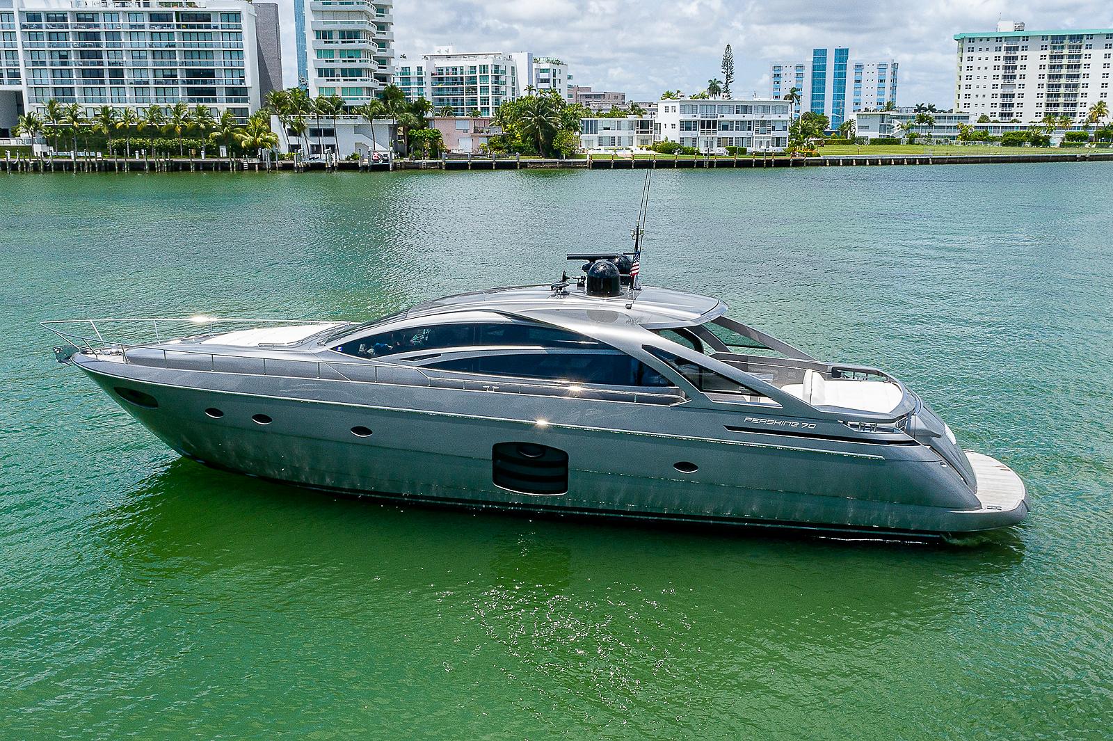 Luxurious 2015 Pershing 70 yacht cruising in a scenic waterfront setting.