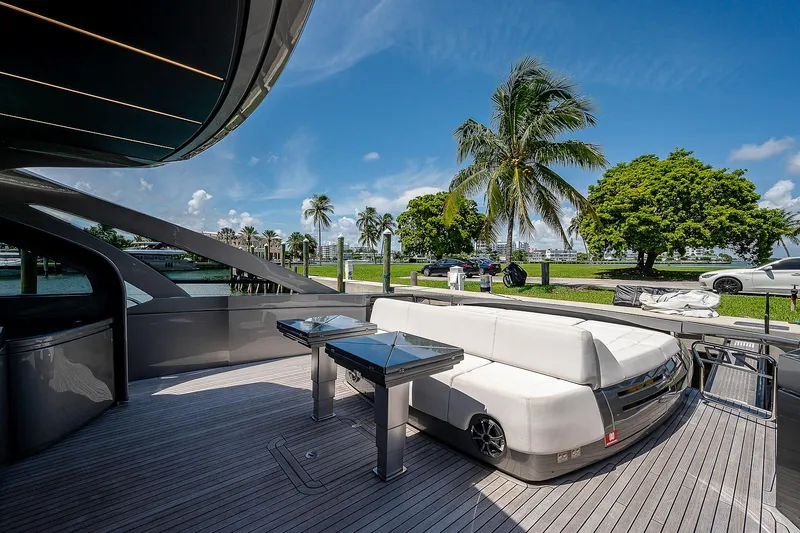 Andiamo Yacht Photos Pics Luxurious 2015 Pershing 70 yacht deck with modern seating and tropical backdrop.