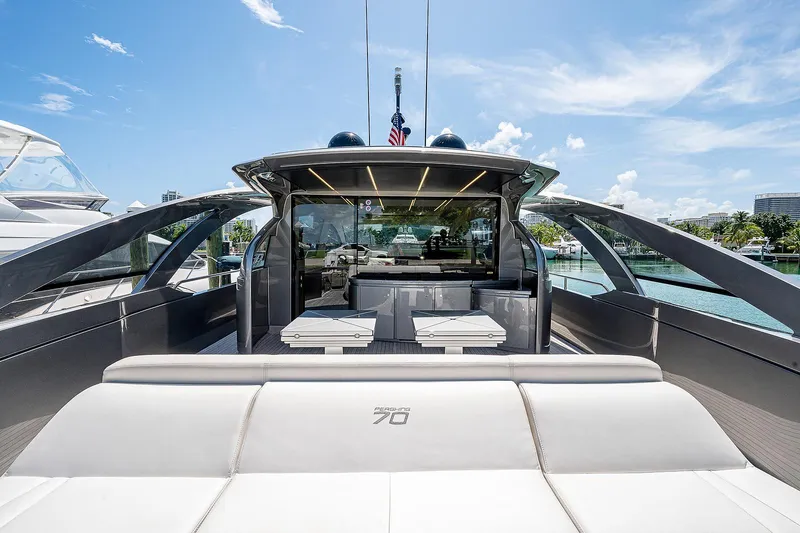 Andiamo Yacht Photos Pics 2015 Pershing 70 yacht with sleek design, luxurious seating, and open deck under clear blue sky.