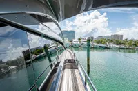 Side view of 2015 Pershing 70 yacht docked in a marina with clear skies.
